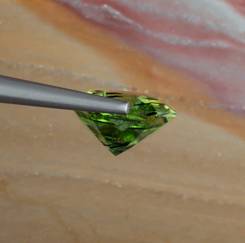 4.99ct Peridot Colored Gemstone with Rutile Inclusions Side View Natural Background
