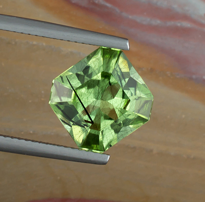 4.99ct Peridot Colored Gemstone with Rutile Inclusions Top View Natural Background