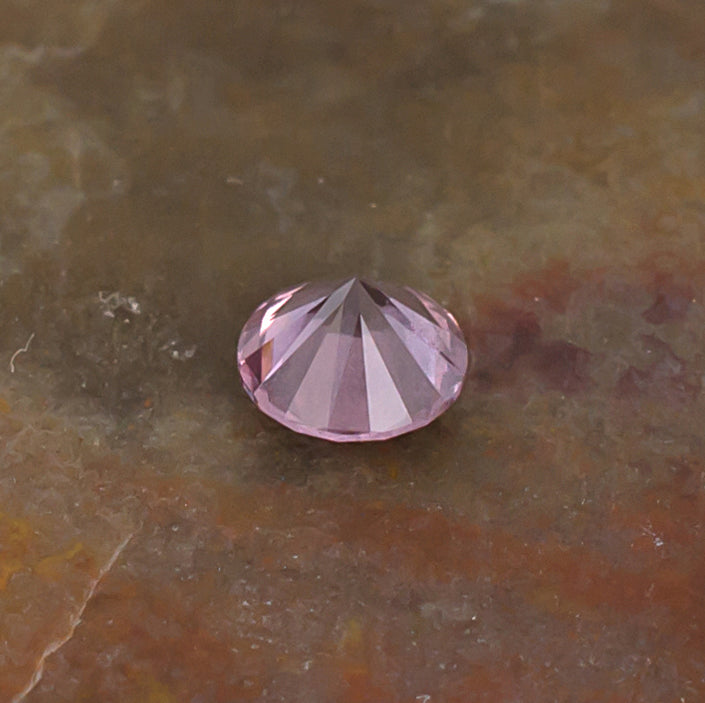 0.41ct Malaya Garnet Colored Gemstone Side Front Natural Background
