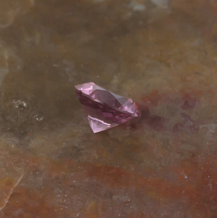 0.41ct Malaya Garnet Colored Gemstone Side Front Natural Background
