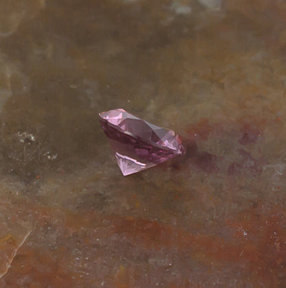 0.41ct Malaya Garnet Colored Gemstone Side Front Natural Background
