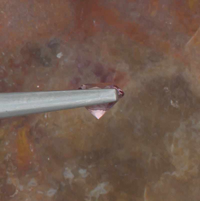 0.59ct Malaya Garnet Colored Gemstone Side View Natural Background 
