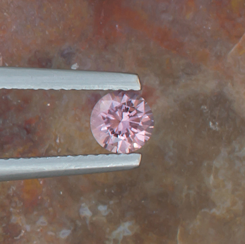 0.59ct Malaya Garnet Colored Gemstone Top View II Natural Background 
