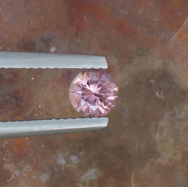 0.59ct Malaya Garnet Colored Gemstone Top View Natural Background 
