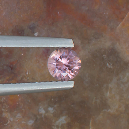 0.59ct Malaya Garnet Colored Gemstone Top View Natural Background 
