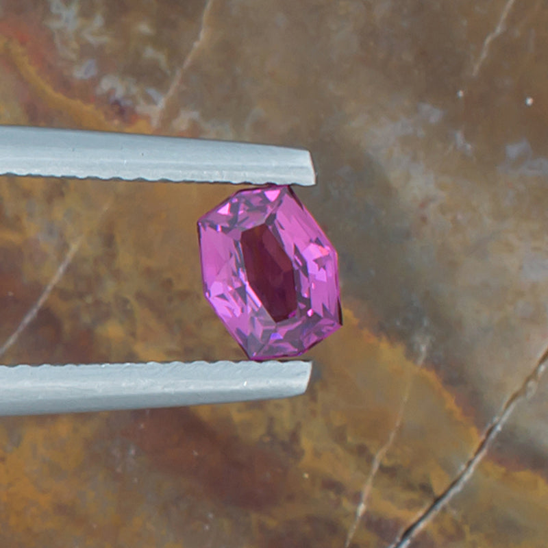 0.83ct Rhodolite Garnet Colored Gemstone Top View Natural Background 
