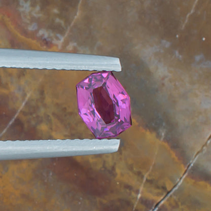 0.83ct Rhodolite Garnet Colored Gemstone Top View Natural Background 
