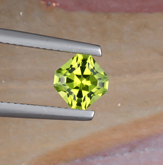 1.10ct Peridot Colored Gemstone Top View Angle Natural Background
