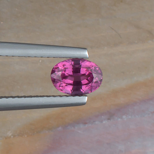 1.11ct Malaya Garnet Colored Gemstone Top View Natural Background
