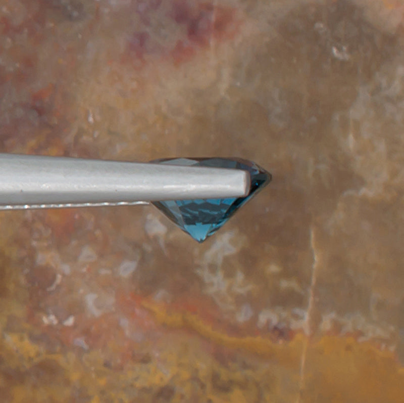 1.24ct Blue Topaz Colored Gemstone Side View Natural Background 
