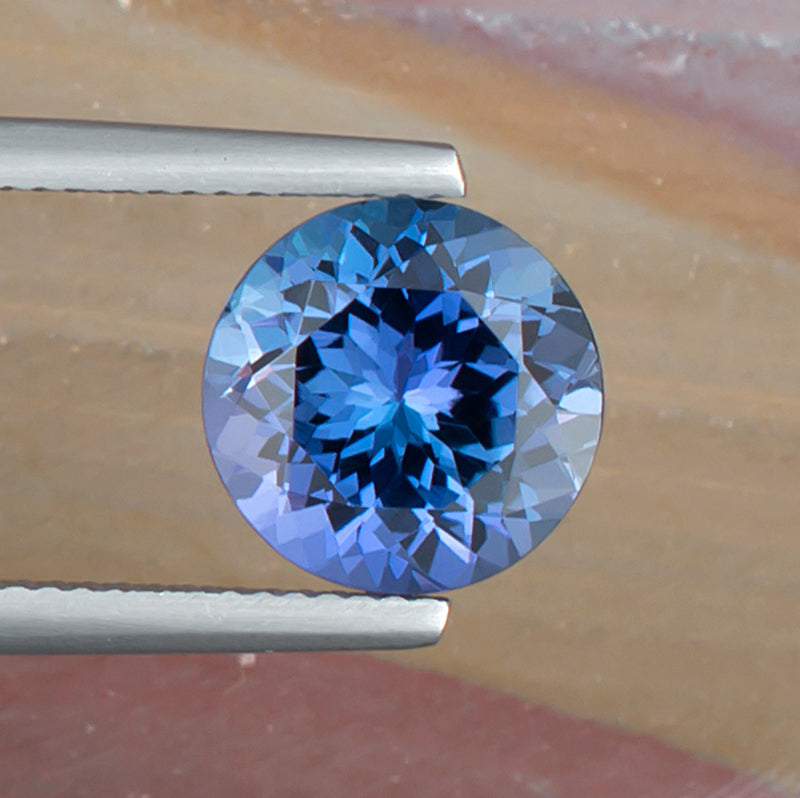 4.42ct Tanzanite Colored Gemstone Top View Tweezers Natural Background 
