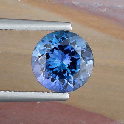 4.42ct Tanzanite Colored Gemstone Top View Tweezers Natural Background 
