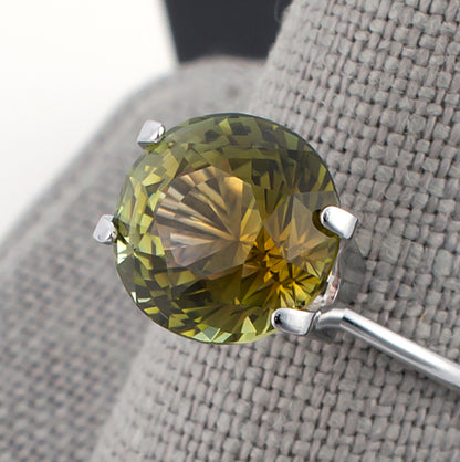4.97ct Yellow Green Tourmaline Colored Gemstone Top View Grey Finger Background
